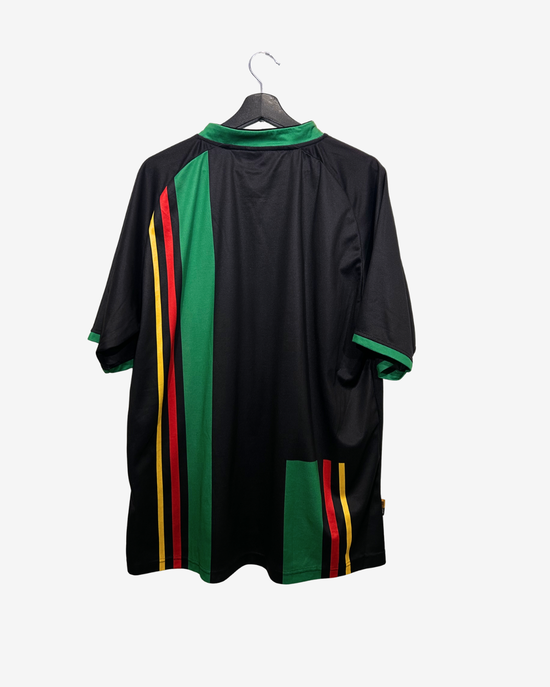Black dress with green and red accents on a hanger against a white background