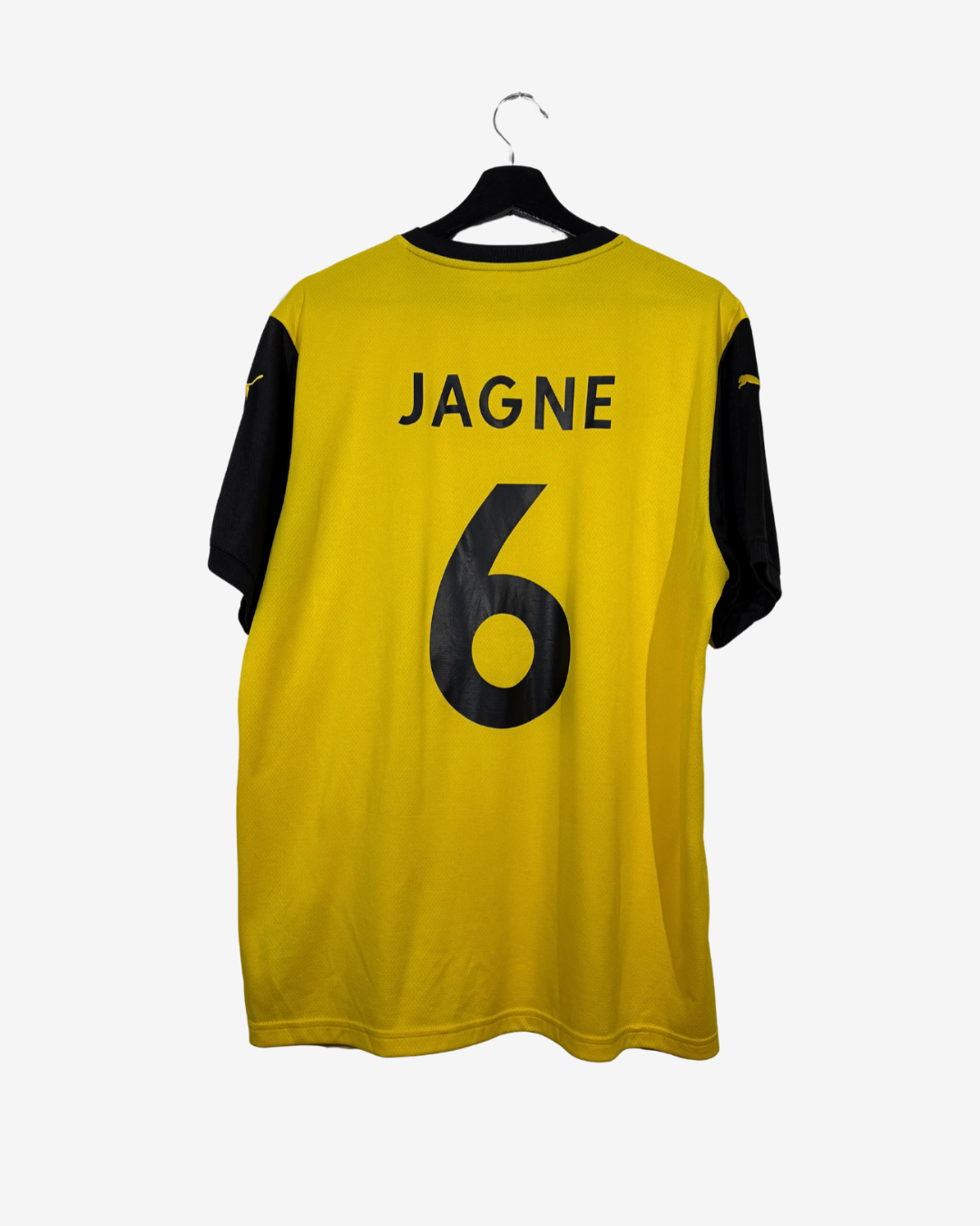 A yellow and black soccer jersey with the name 'JAGNE' and number '6' printed on the back, hanging on a black hanger against a light gray background.