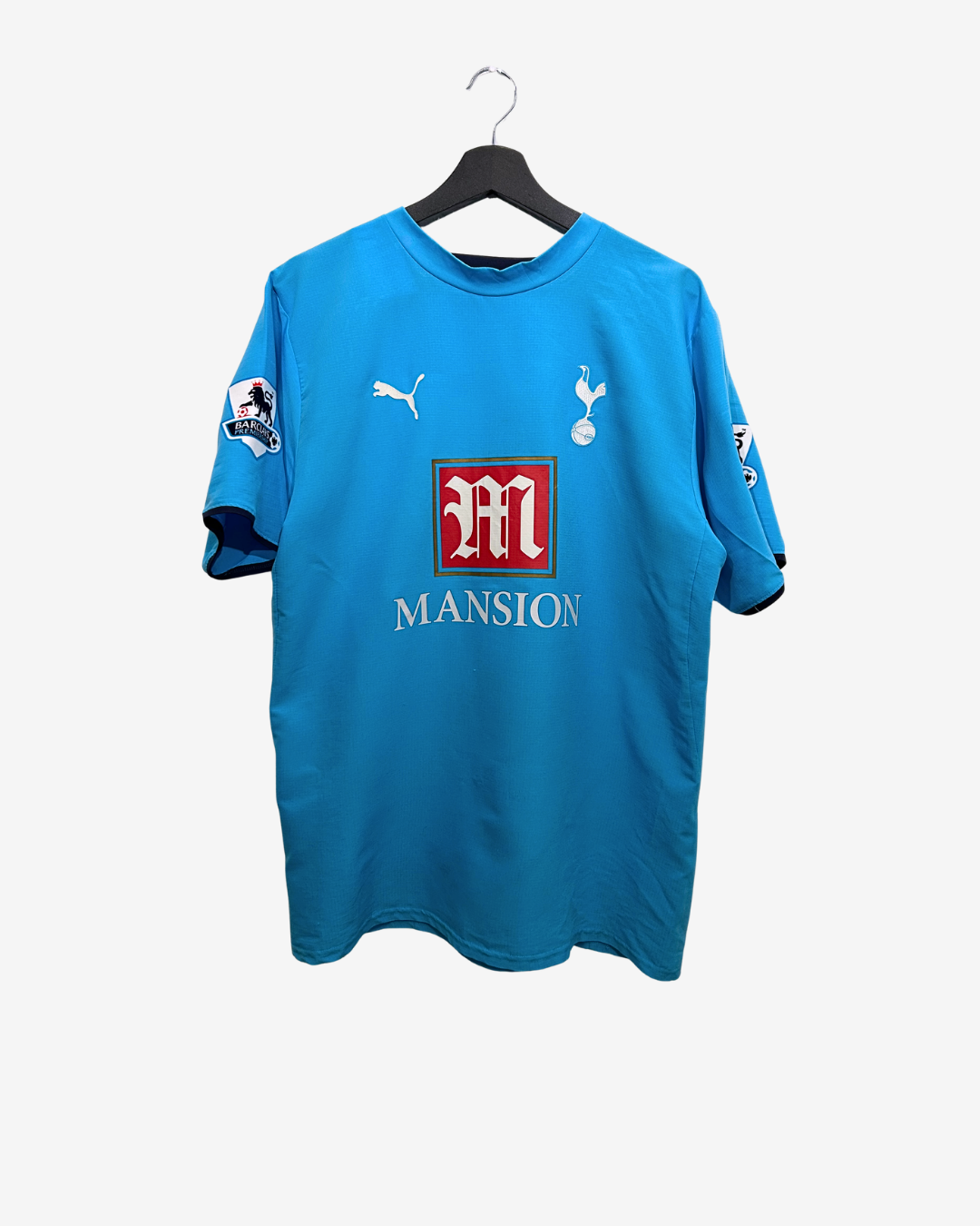 Blue sports jersey with logos on a hanger against a white background