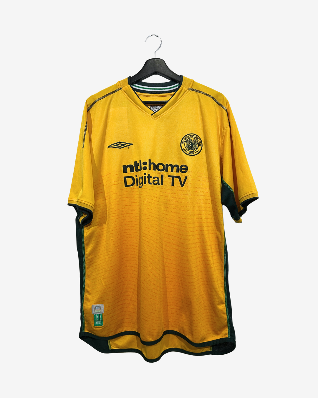 A yellow and green Scotland football jersey with 'mtshome Digital TV' sponsor logo, hanging on a black hanger against a light gray background.