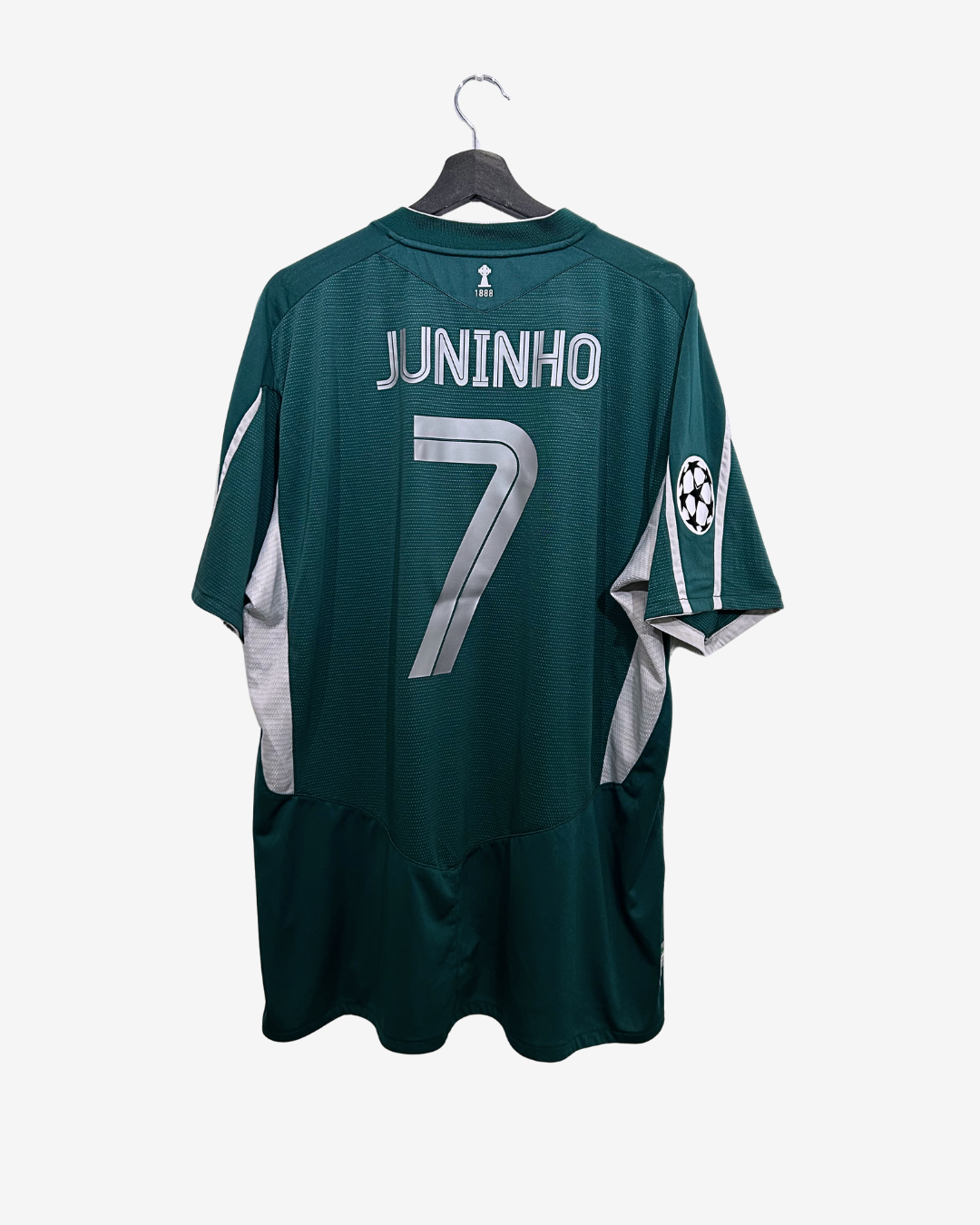 Green sports jersey with 'Juninho' and number '7' on a hanger against a white background