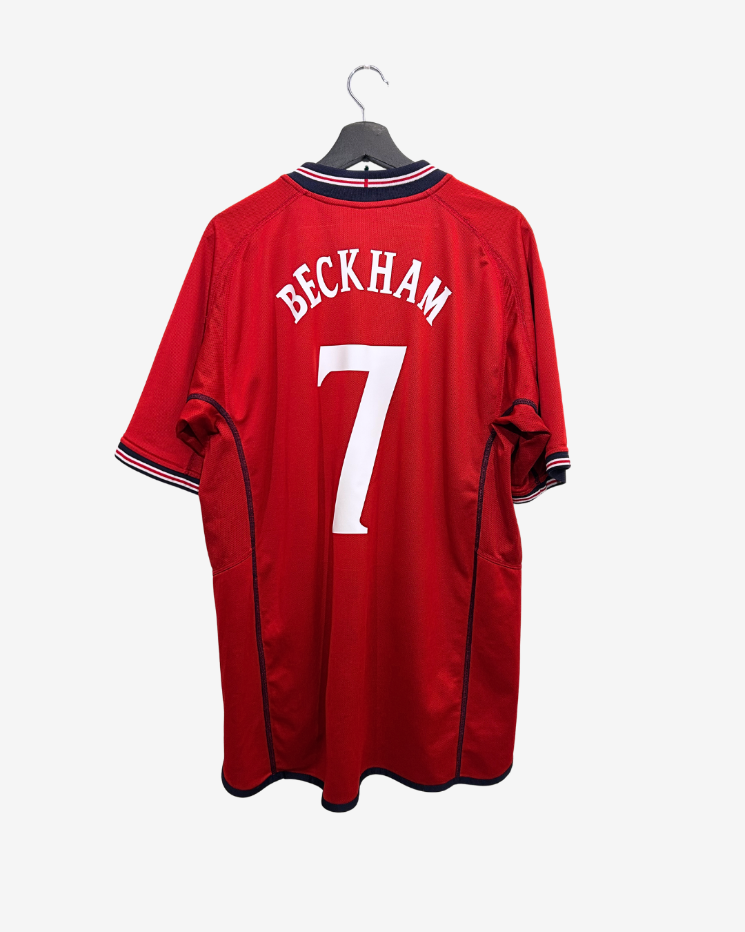 Red sports jersey with 'Beckham' and number '7' on a hanger against a white background