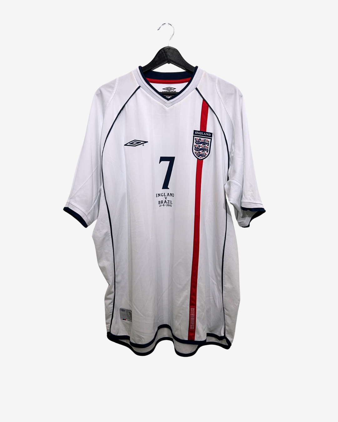 White sports jersey with red stripe and number 7 on a hanger against a white background