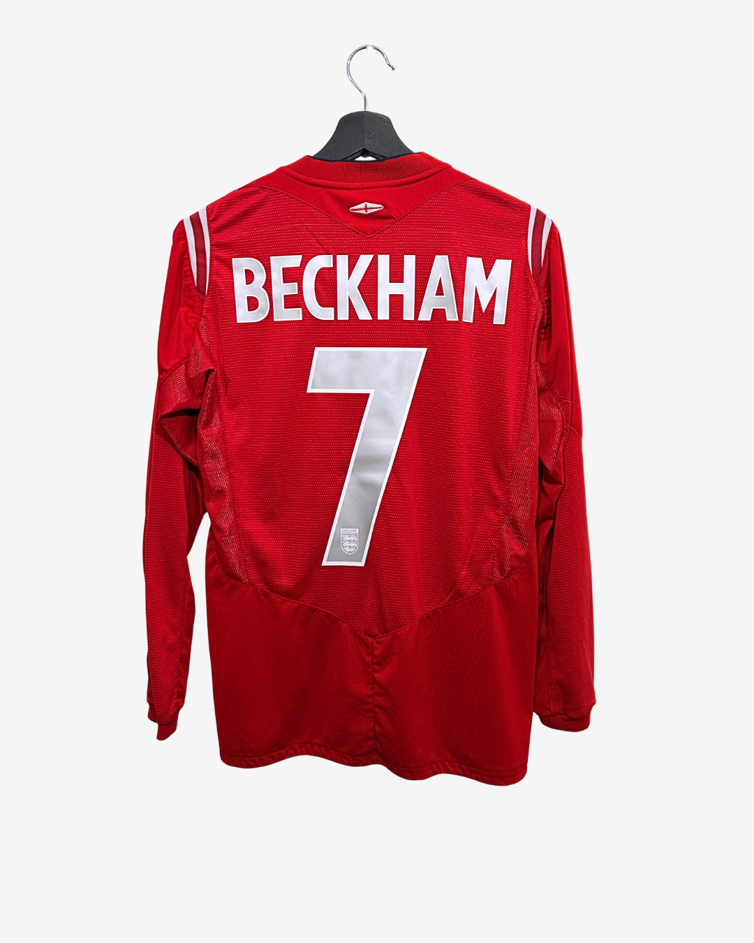 Red sports jersey with 'BECKHAM' and number '7' on a hanger against a white background