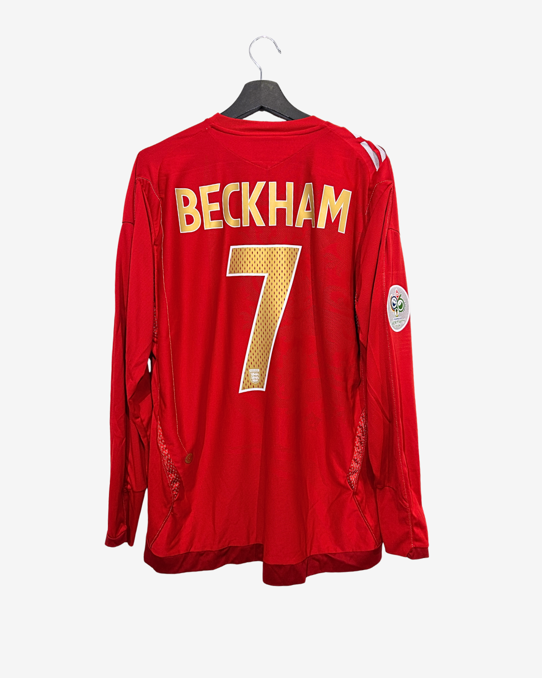 Red sports jersey with 'Beckham' and number '7' on a hanger against a white background