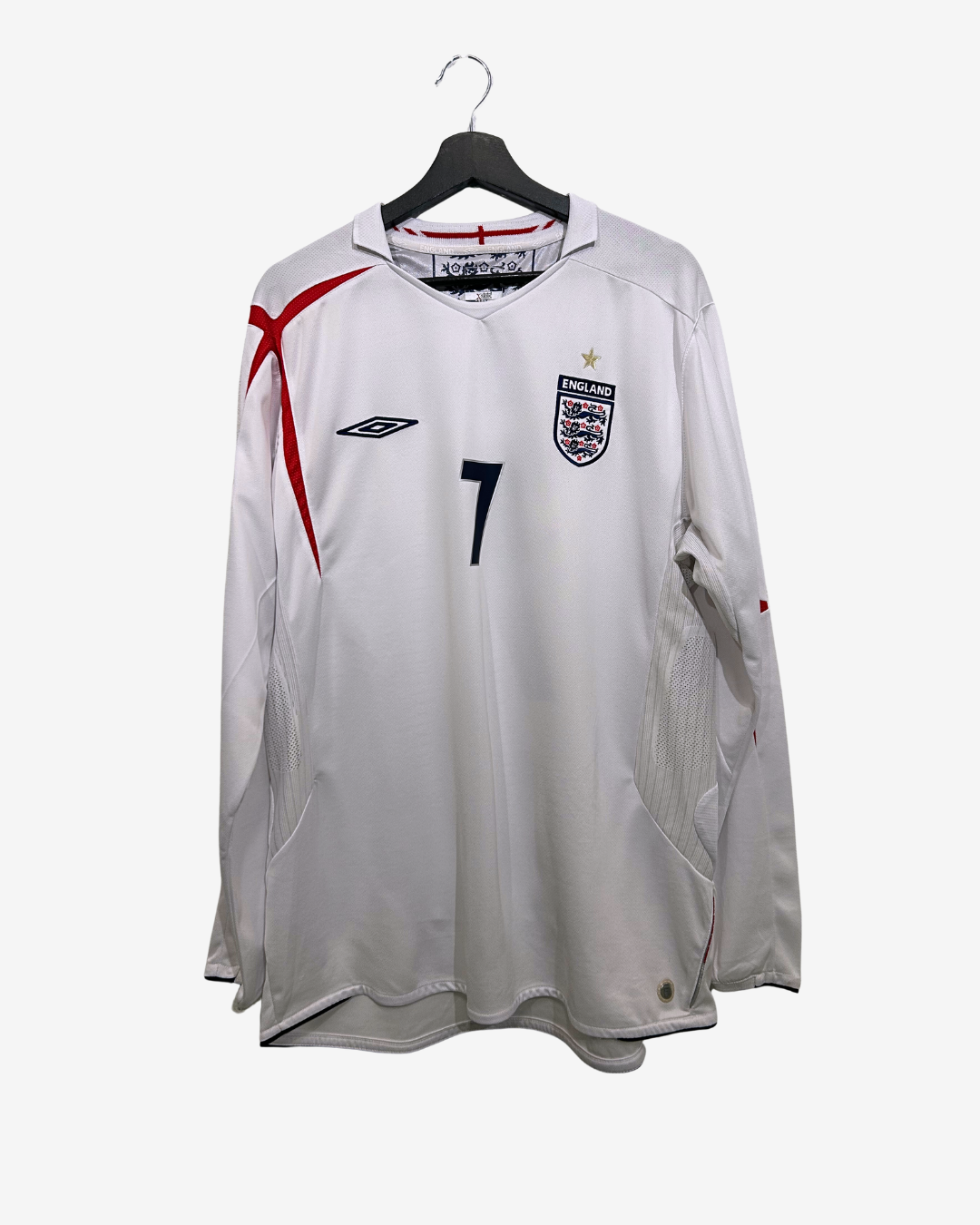 White sports jersey with red and black design on a hanger against a white background