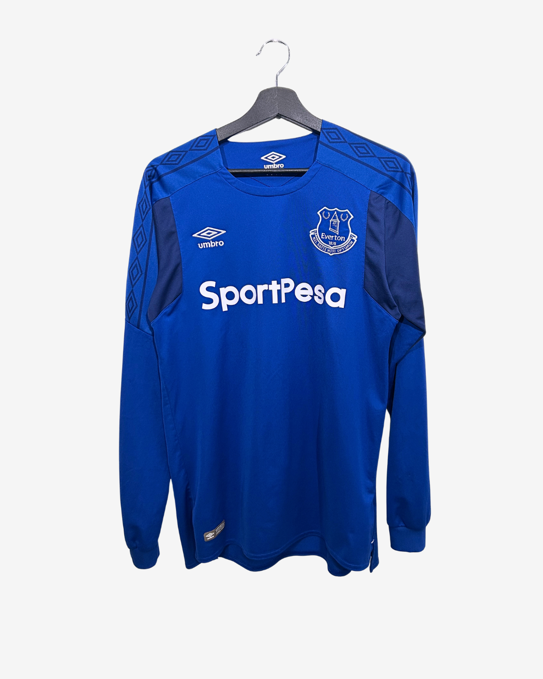 Blue sports jersey with 'SportPesa' and Umbro logos on a hanger against a white background
