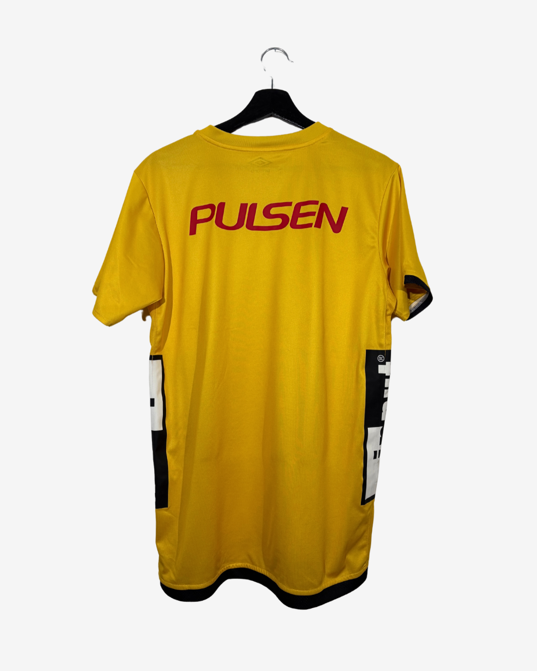 A yellow short-sleeve athletic jersey with 'PULSEN' printed in red across the upper back, hanging on a black hanger against a light gray background.