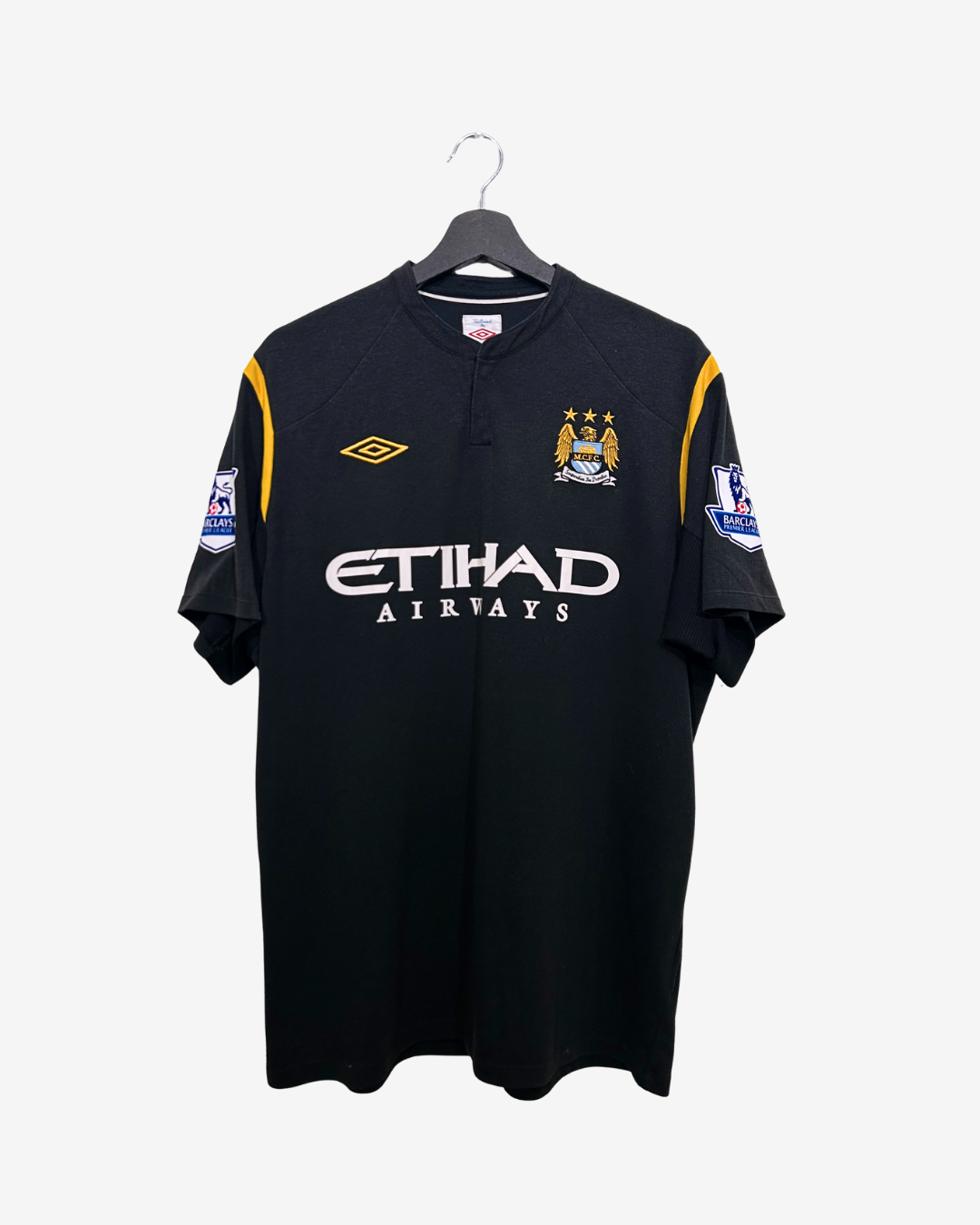 Black sports jersey with yellow accents on a hanger against a white background