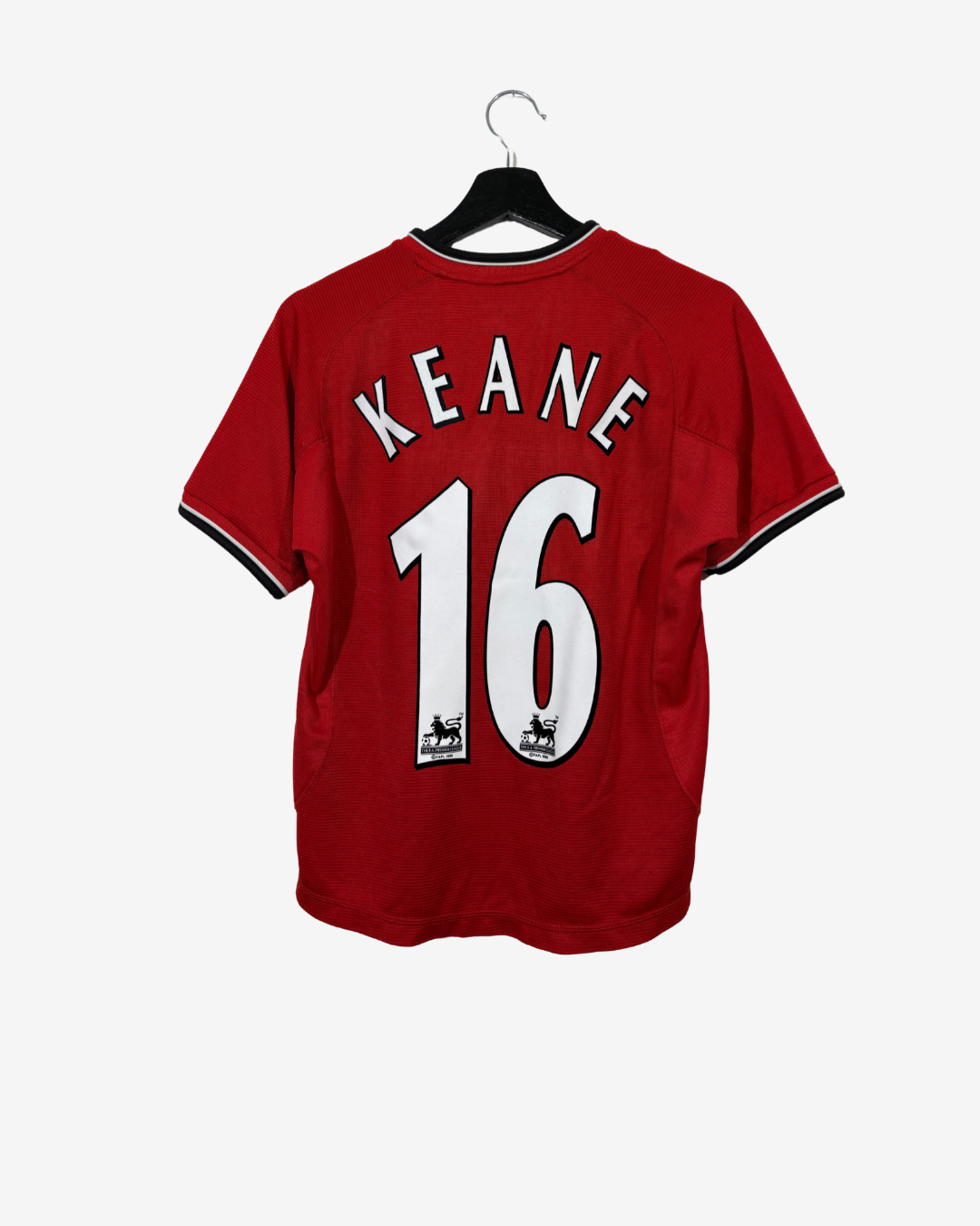 A red short-sleeve soccer jersey hanging on a black hanger against a light gray background. The back of the jersey features the name 'KEANE' in white arched letters above the number '16' in white, with black trim on the sleeve cuffs.