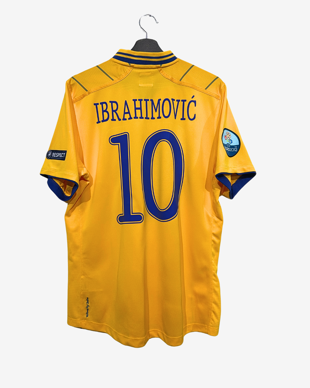 Yellow sports jersey with 'Ibrahimovic' and number '10' on a hanger against a white background