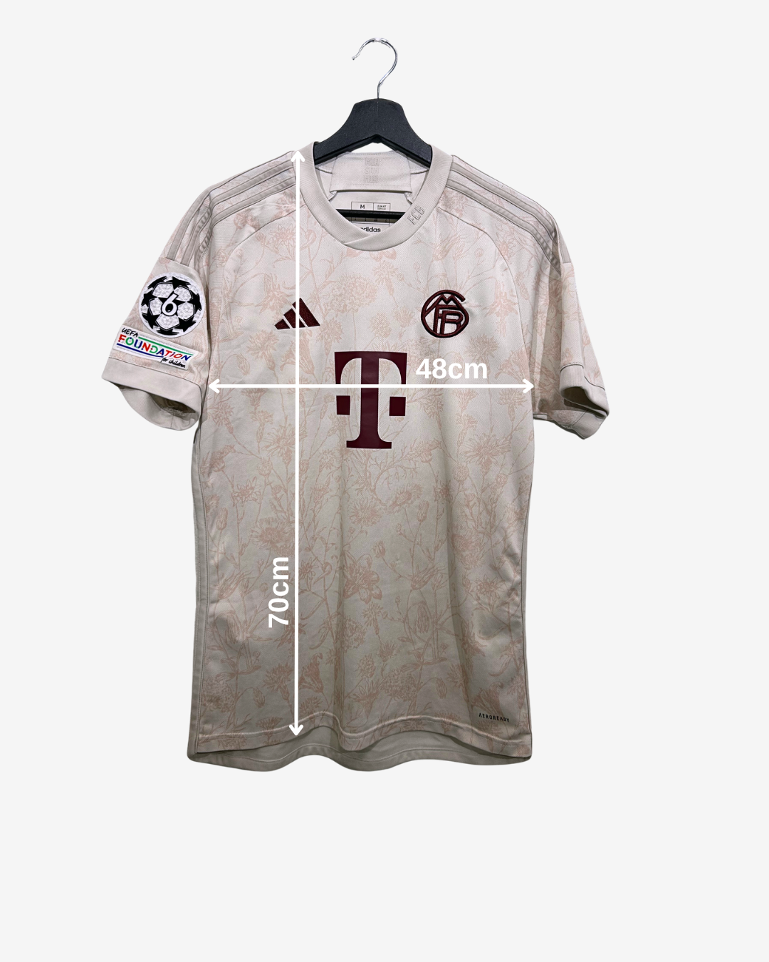 Gray sports jersey with brand logos on a white background, showing measurements.