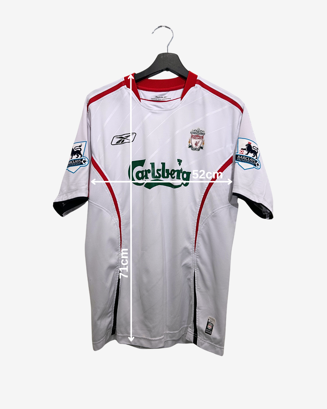 White sports jersey with red and black accents on a hanger, featuring visible branding.