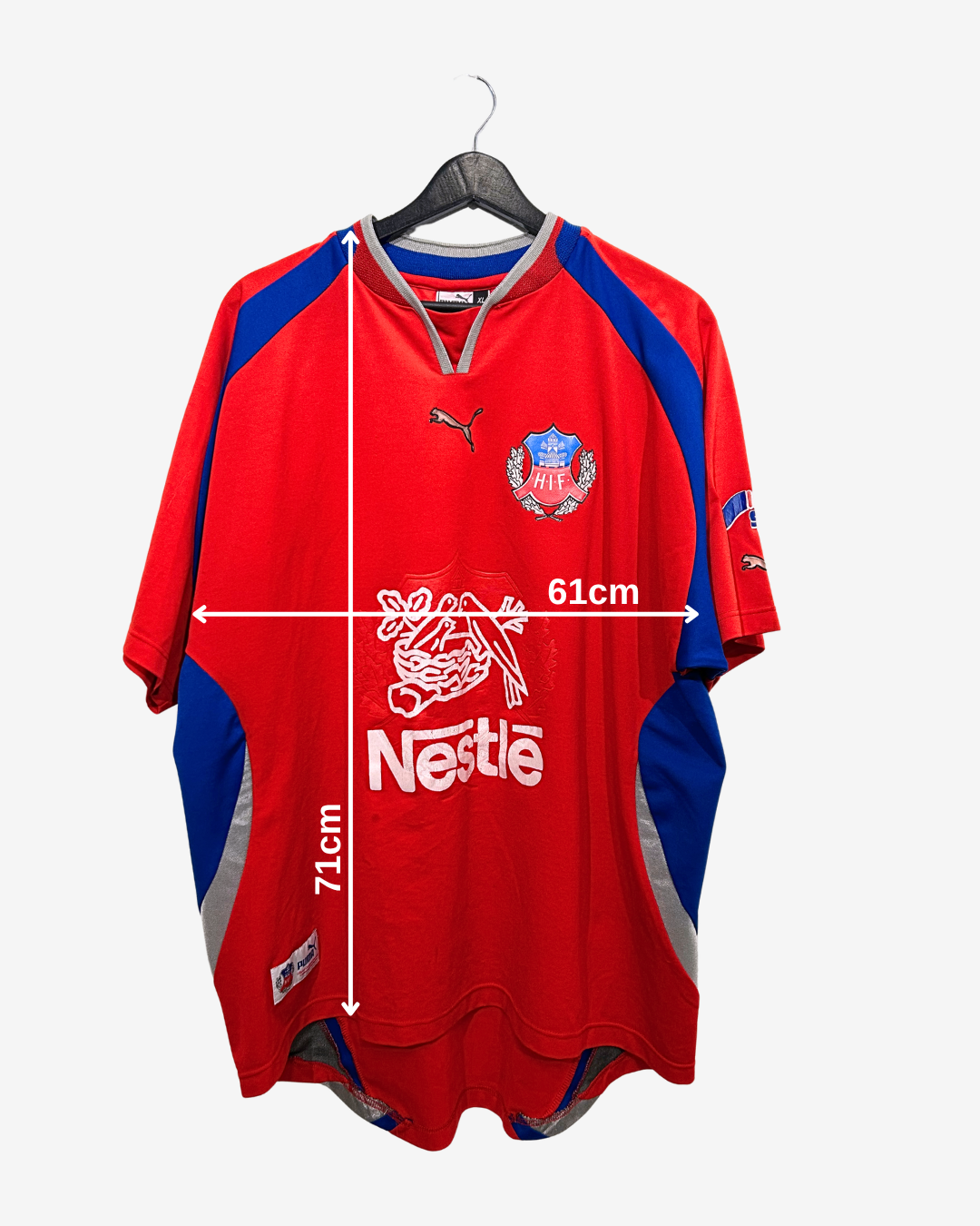 Red sports jersey with blue sleeves on a hanger, featuring Nestle logo, with measurements indicated.