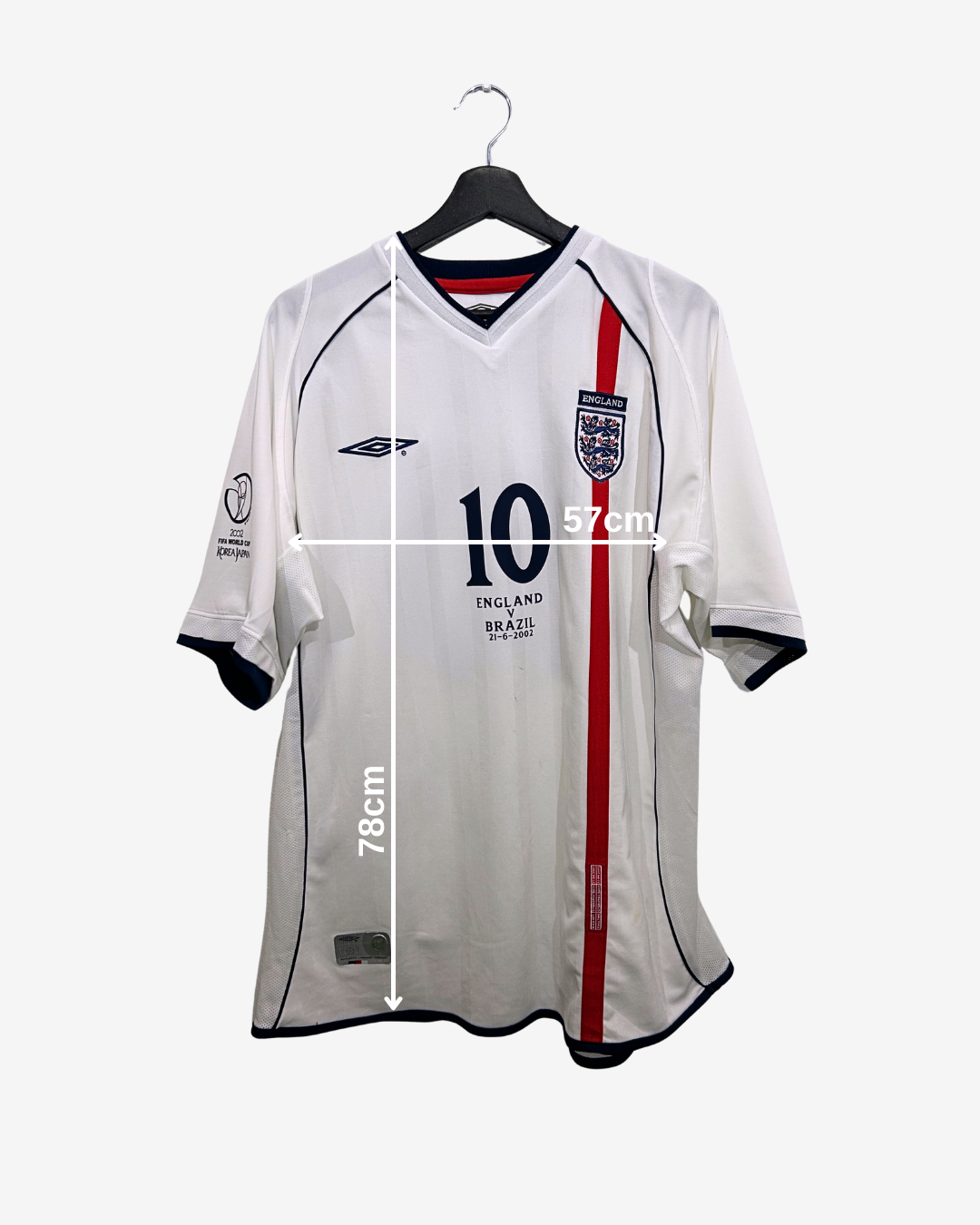 White sports jersey with red stripe on a hanger, measurement labels visible