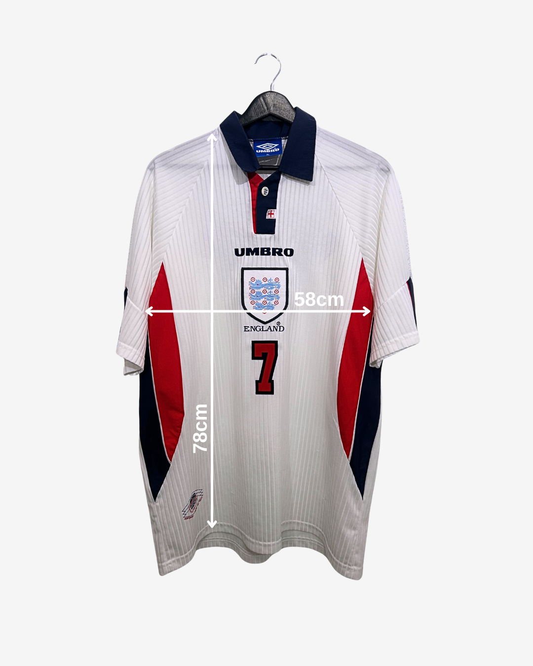 White sports jersey with red and blue accents on a hanger, featuring measurements and branding.