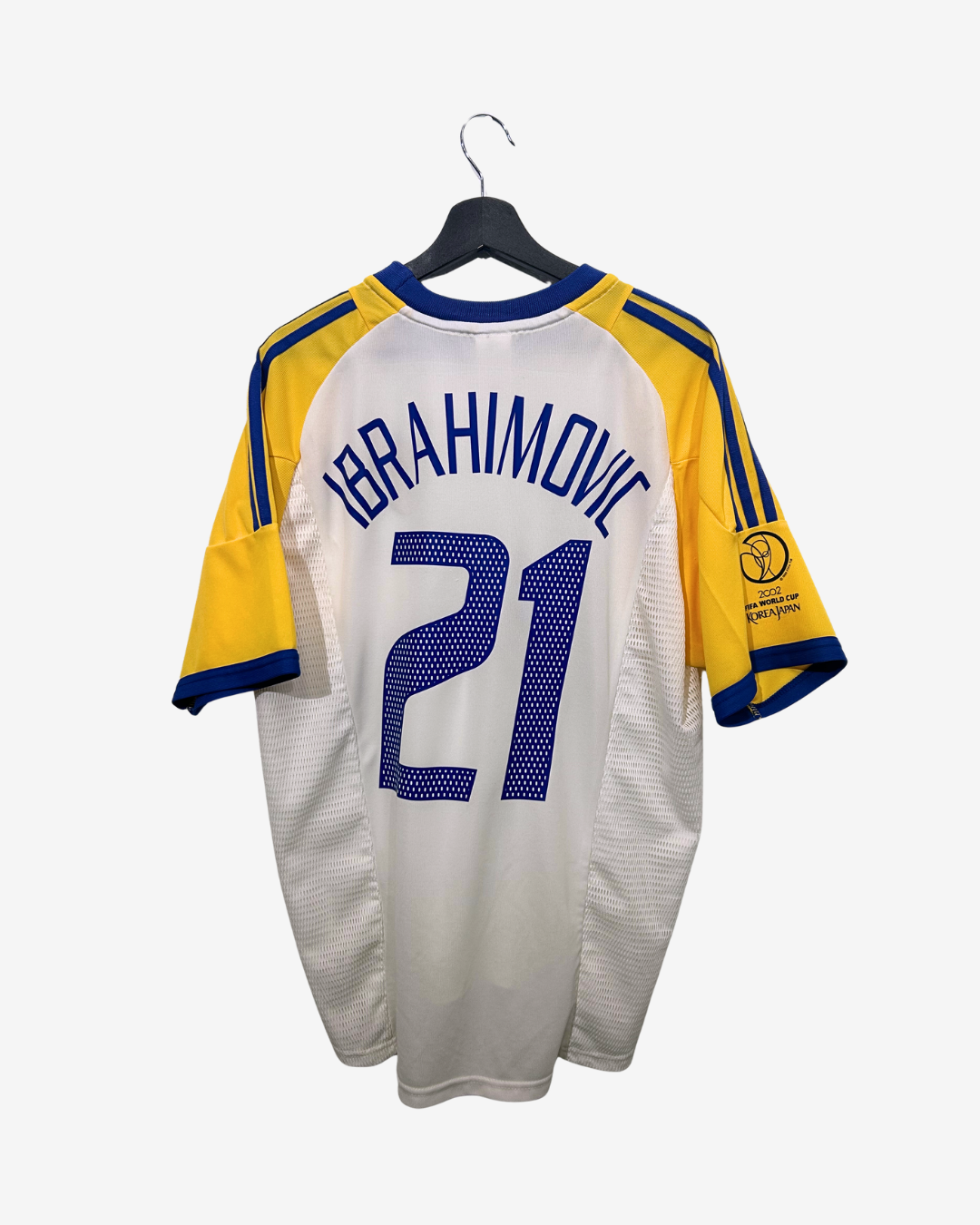 White sports jersey with yellow sleeves and blue accents, featuring the name 'Ibrahimovic' and number '21', on a hanger against a white background.