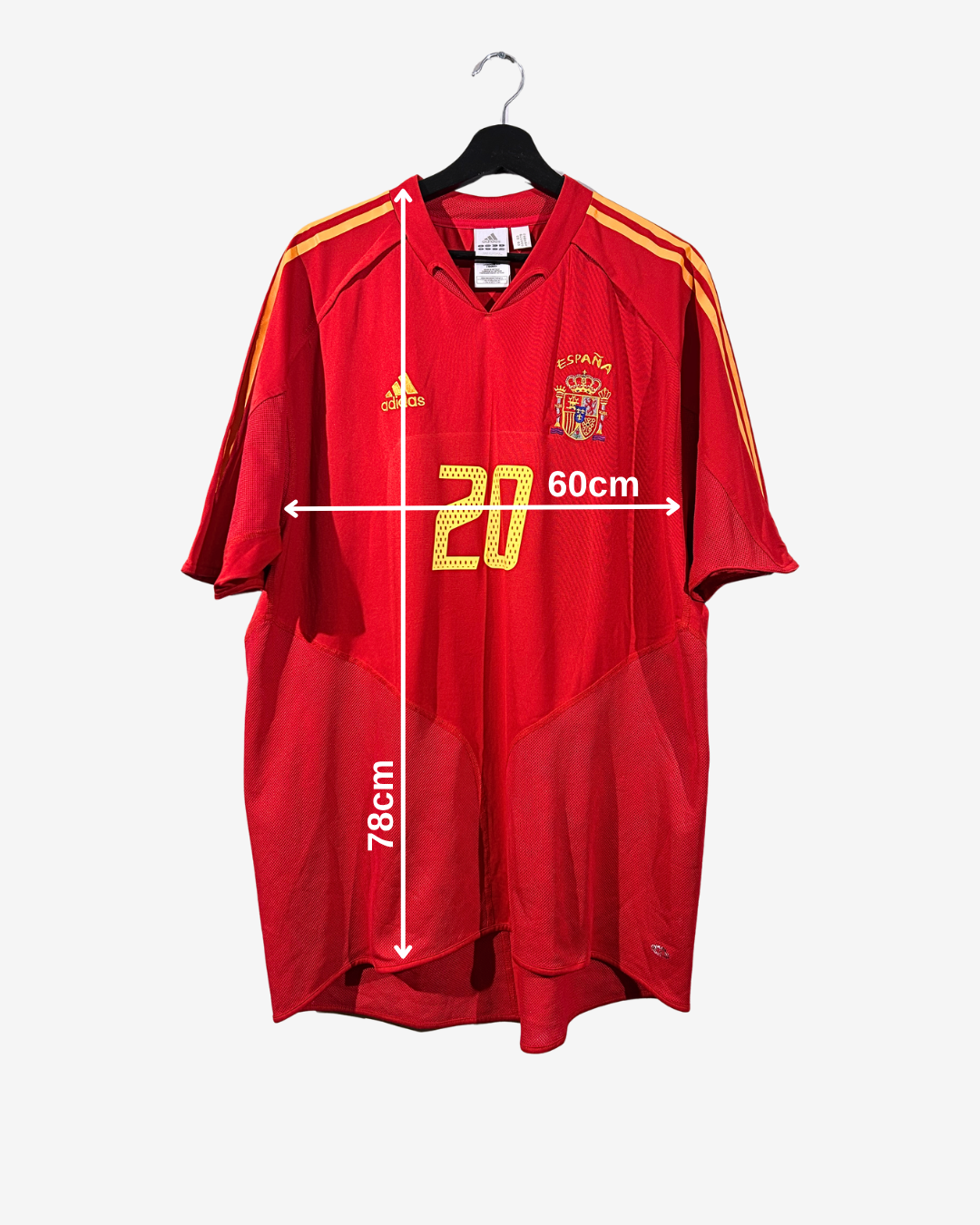 Red sports jersey with yellow stripes and measurements on a white background
