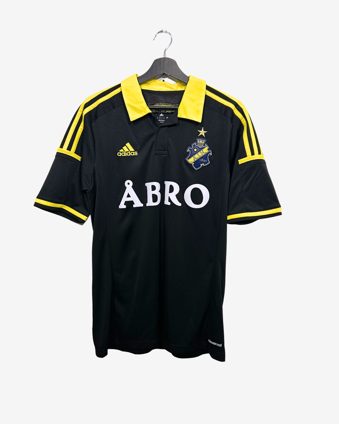 Black sports jersey with yellow accents and 'ABRO' branding on a hanger against a white background