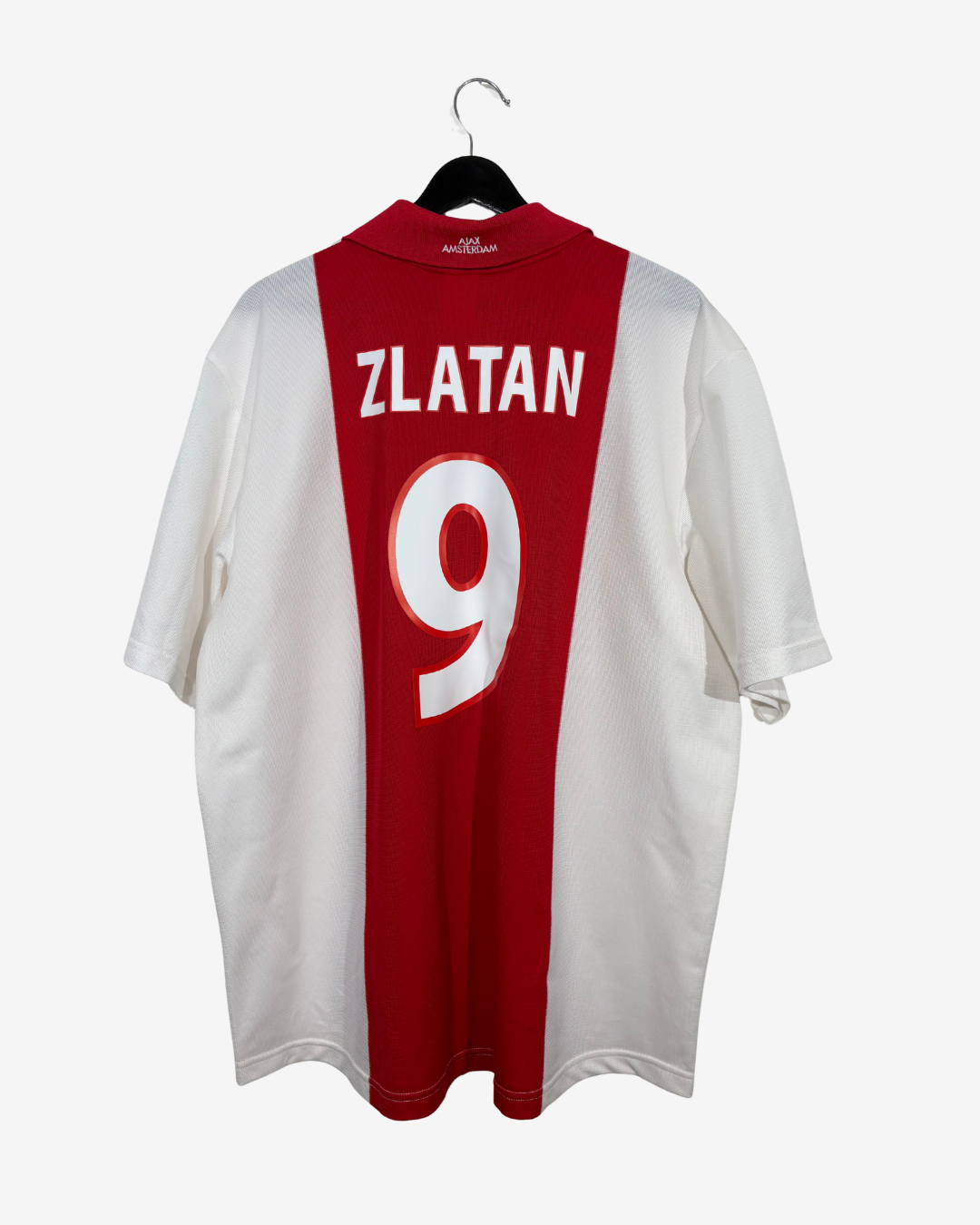 A red and white striped football jersey with 'ZLATAN' and the number '9' printed on the back, hanging on a black hanger against a light gray background.