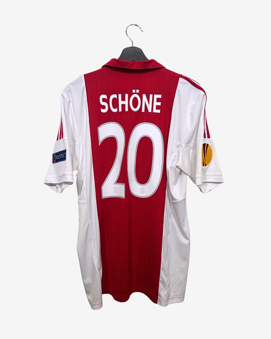 Red and white sports jersey with 'SCHÖNE' and number '20' on a hanger against a white background