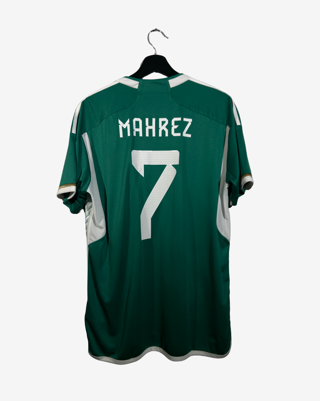 Green sports jersey with 'Mahrez' and number '7' on a hanger against a white background