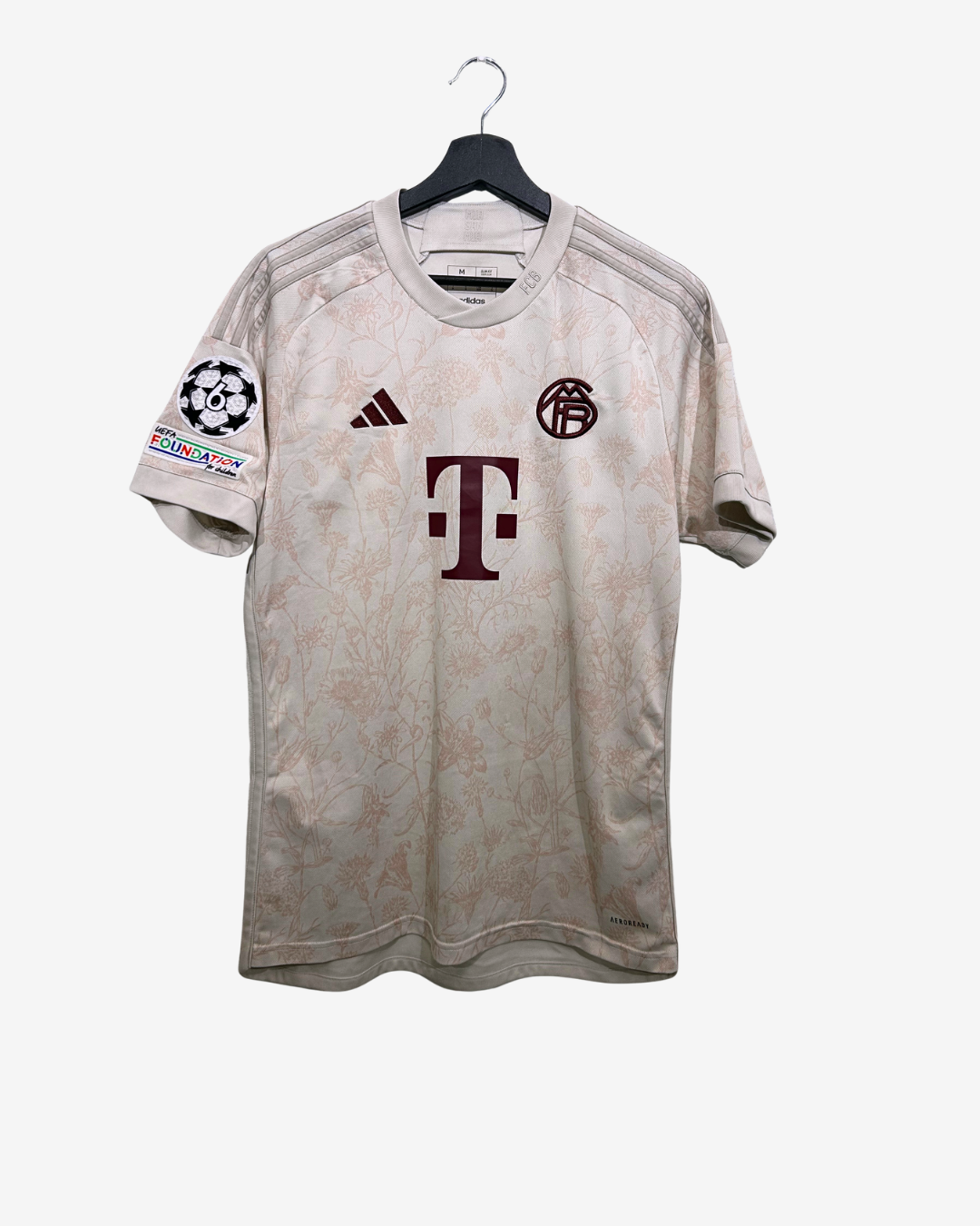Beige sports jersey with logos on a white background