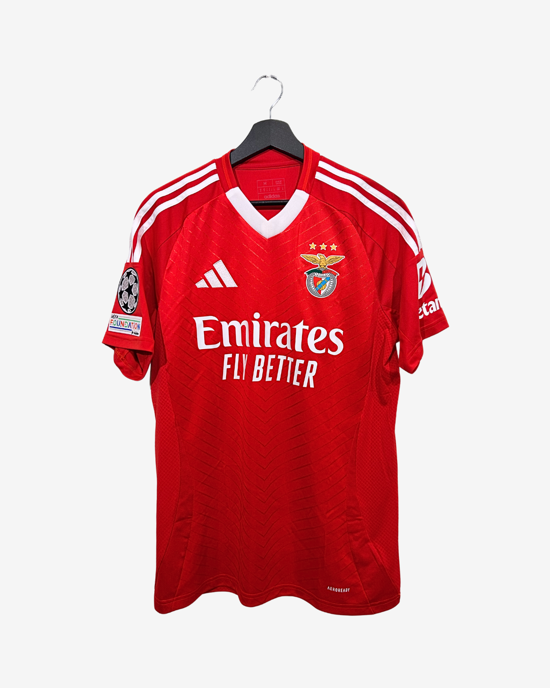 Red sports jersey with white accents on a hanger against a white background