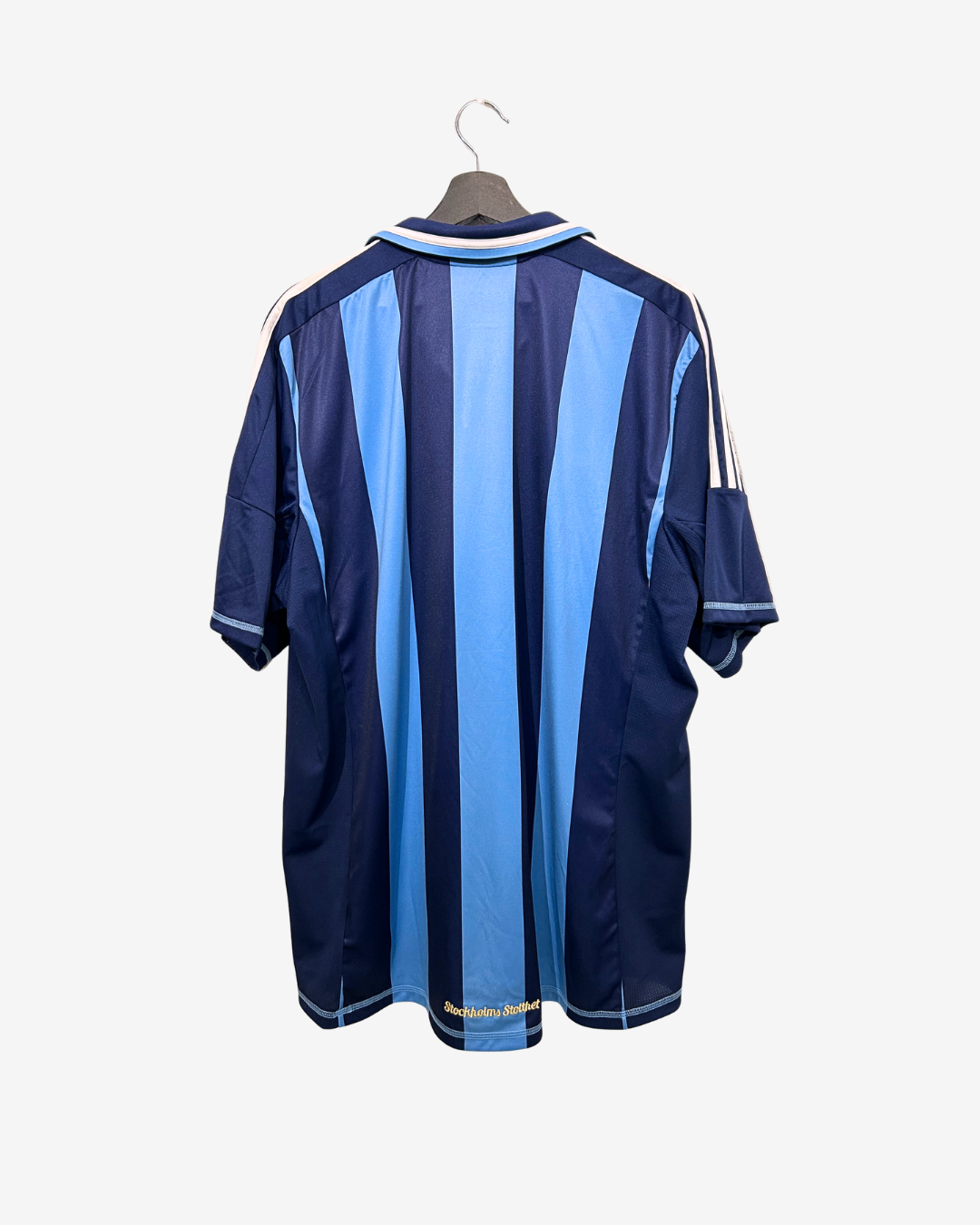 Navy and light blue striped shirt on a hanger against a white background