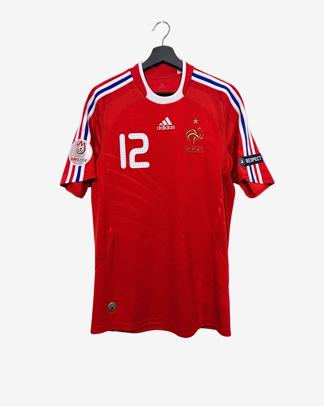 Red soccer jersey with number 12 and Adidas logo on a hanger