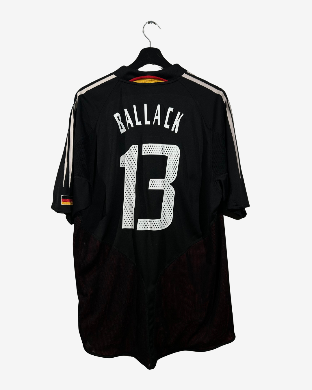 Black sports jersey with 'Ballack' and number '13' on a hanger against a white background