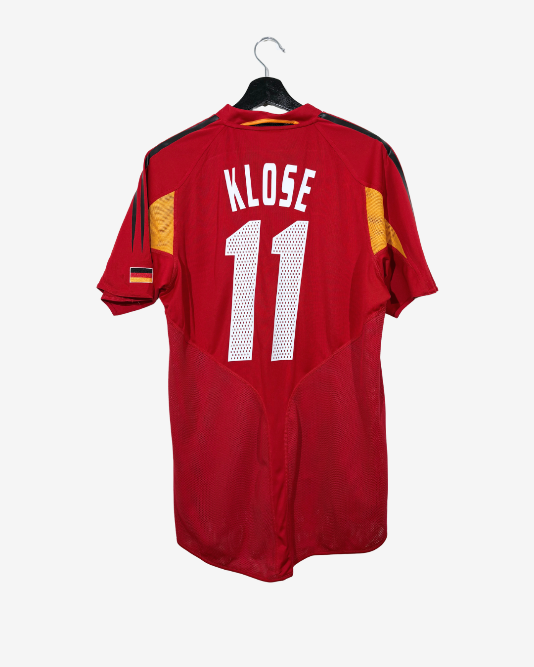 A red Germany national football team jersey with 'KLOSE' and the number '11' on the back, hanging on a black hanger against a light gray background.