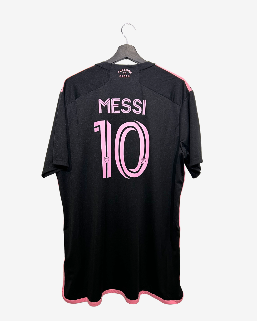 Black sports jersey with 'Messi 10' printed on a hanger against a white background