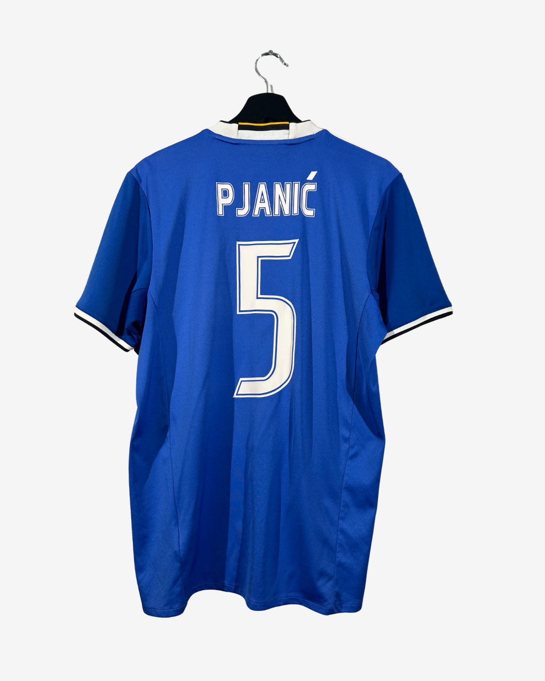 A royal blue soccer jersey hanging on a black hanger against a light gray background. The back of the shirt features the name 'PJANIČ' and the number '5' in white with black outlines.