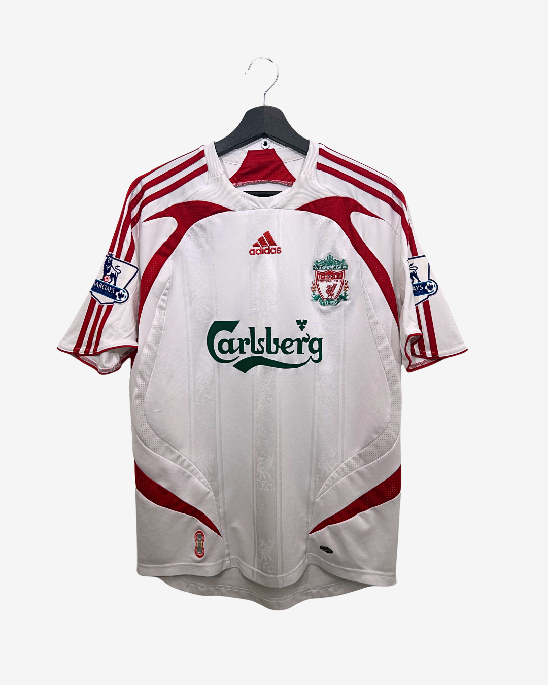 White sports jersey with red accents and Adidas logo on a hanger against a white background