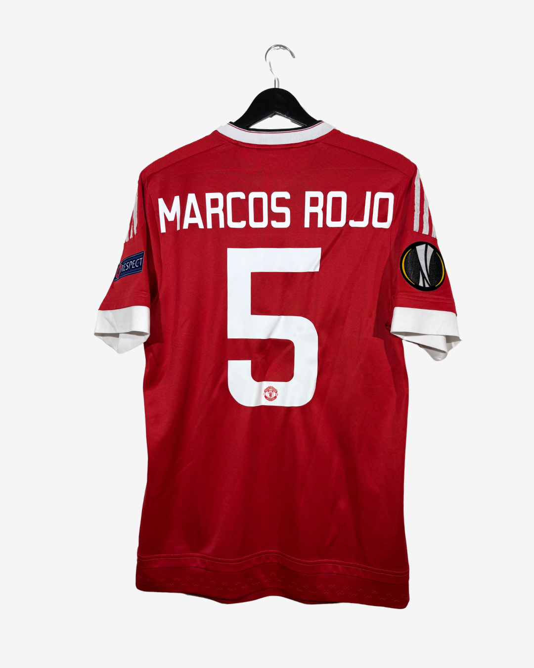 A red soccer jersey hanging on a black hanger against a light gray background. The back of the jersey features 'MARCOS ROJO' and the number '5' in white, with white sleeve trim and UEFA Europa League patches on the sleeves.