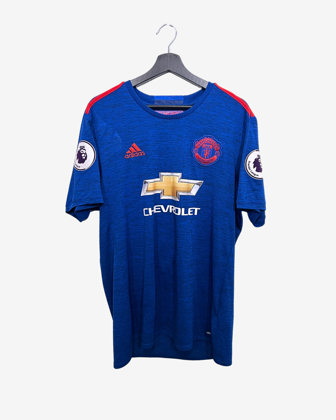 Blue sports jersey with brand logos on a hanger against a white background