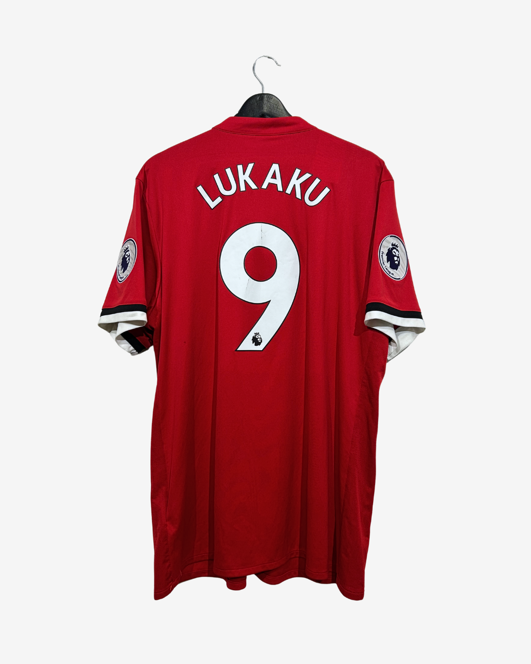 A red short-sleeve football jersey hanging on a black hanger against a light gray background. The back of the shirt features the name 'LUAKU' in white block letters above a large white number '9'.