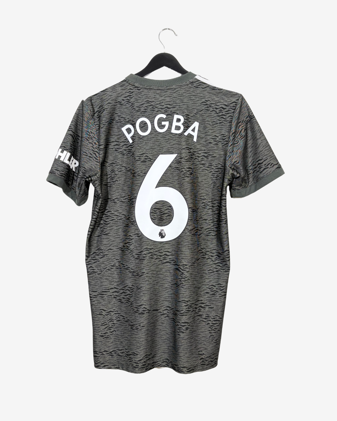 A dark gray patterned short-sleeve soccer jersey hanging on a black hanger against a light gray background. The back of the shirt features the name 'POGBA' and number '6' in white.