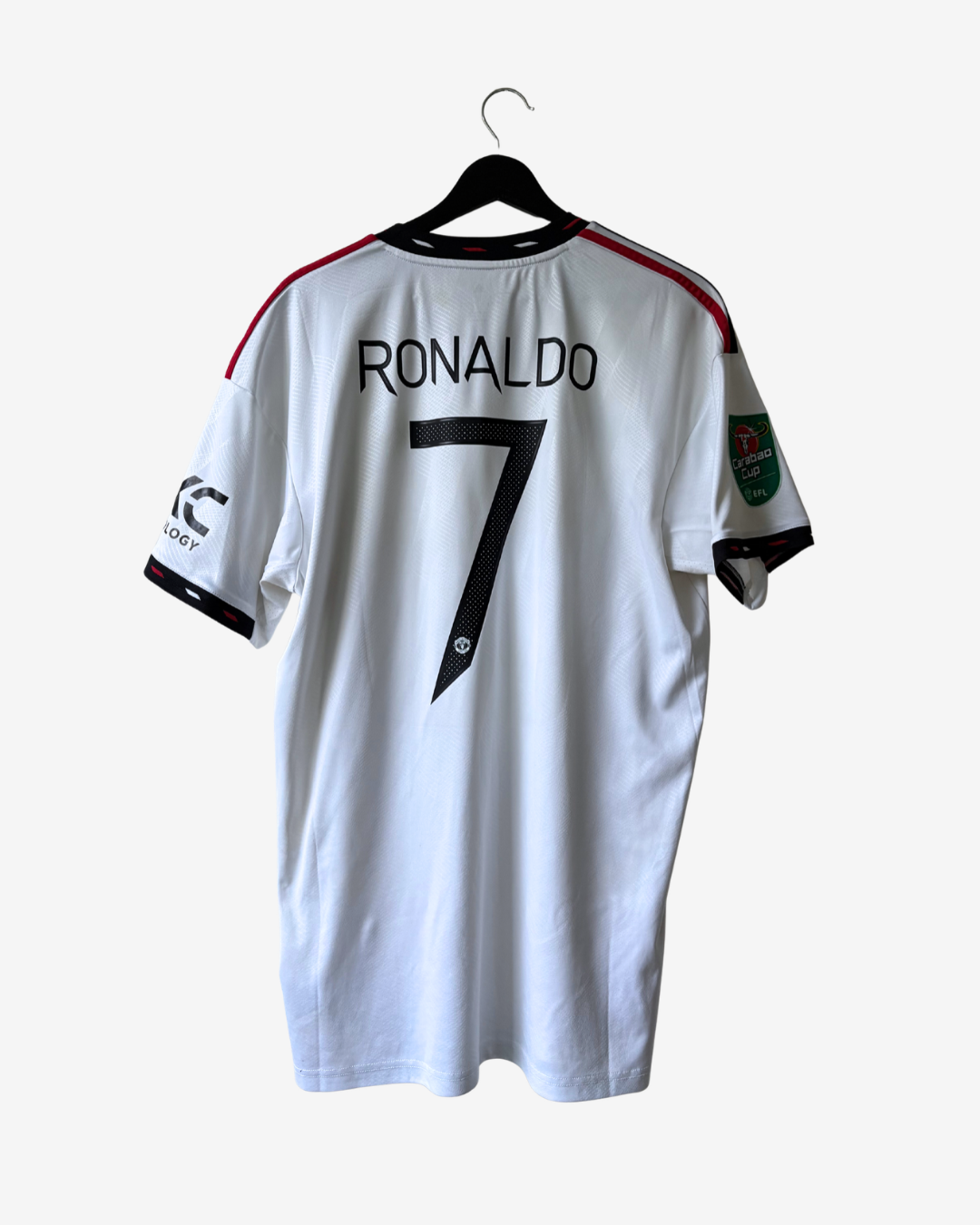 White Manchester United national football team jersey with 'RONALDO 7' printed on the back, hanging on a black hanger against a light gray background.