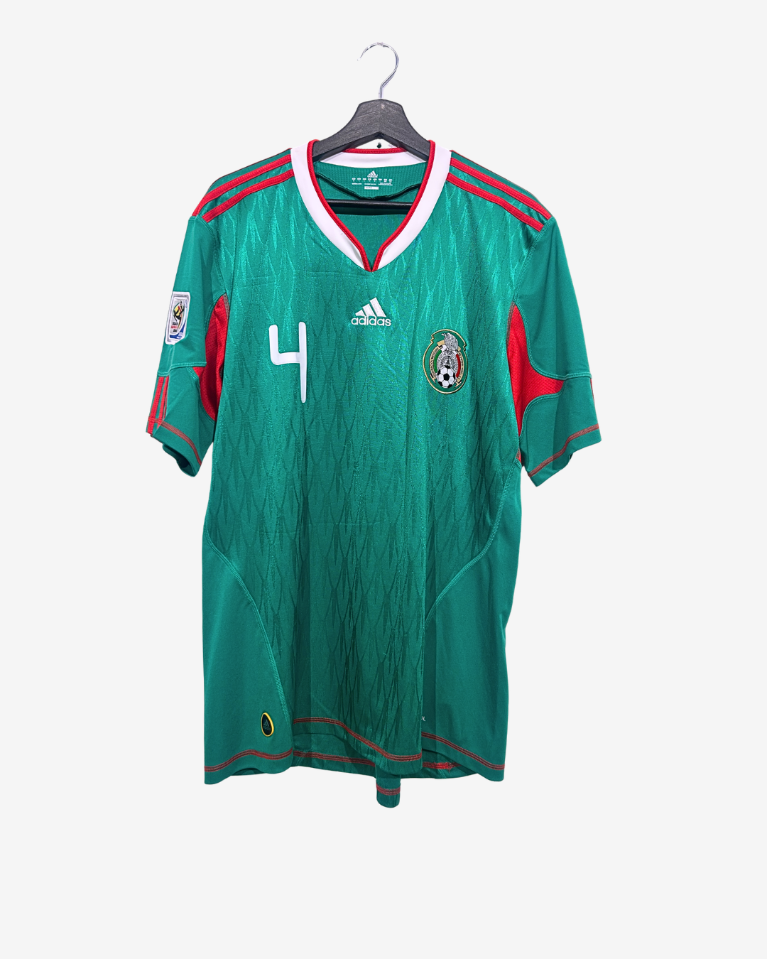 Green soccer jersey with red accents on a hanger against a white background