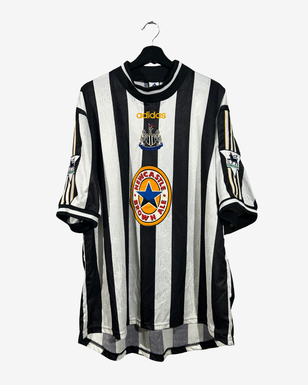 Black and white striped sports jersey with Adidas logo on a hanger