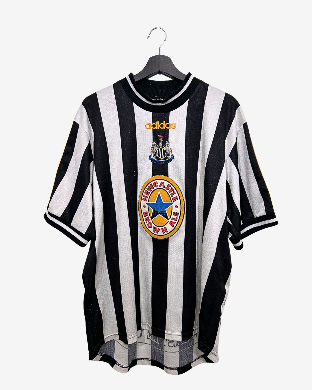 Black and white striped sports jersey with Adidas logo on a hanger