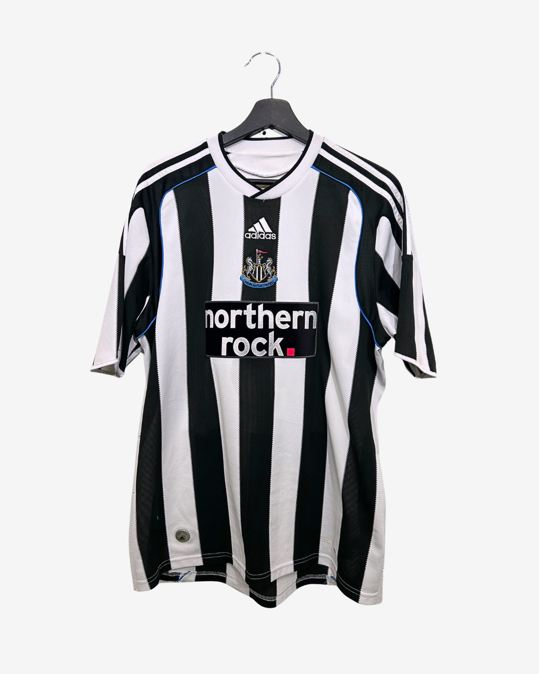 Black and white striped sports jersey with Adidas logo on a hanger against a white background