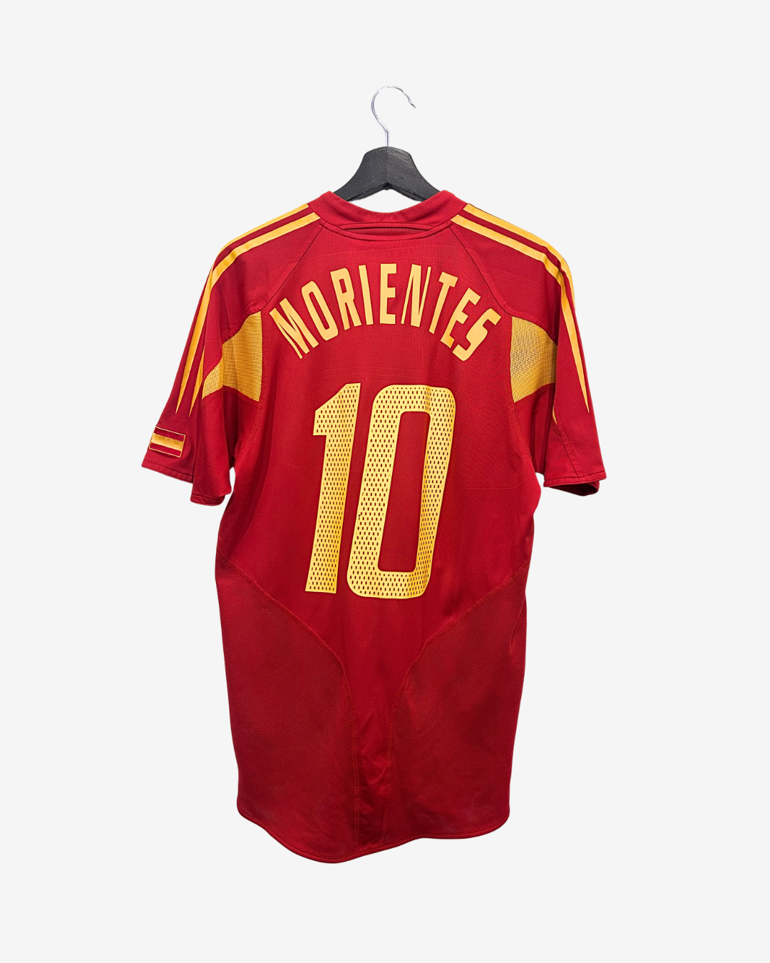 Red sports jersey with yellow text and numbering on a hanger against a white background