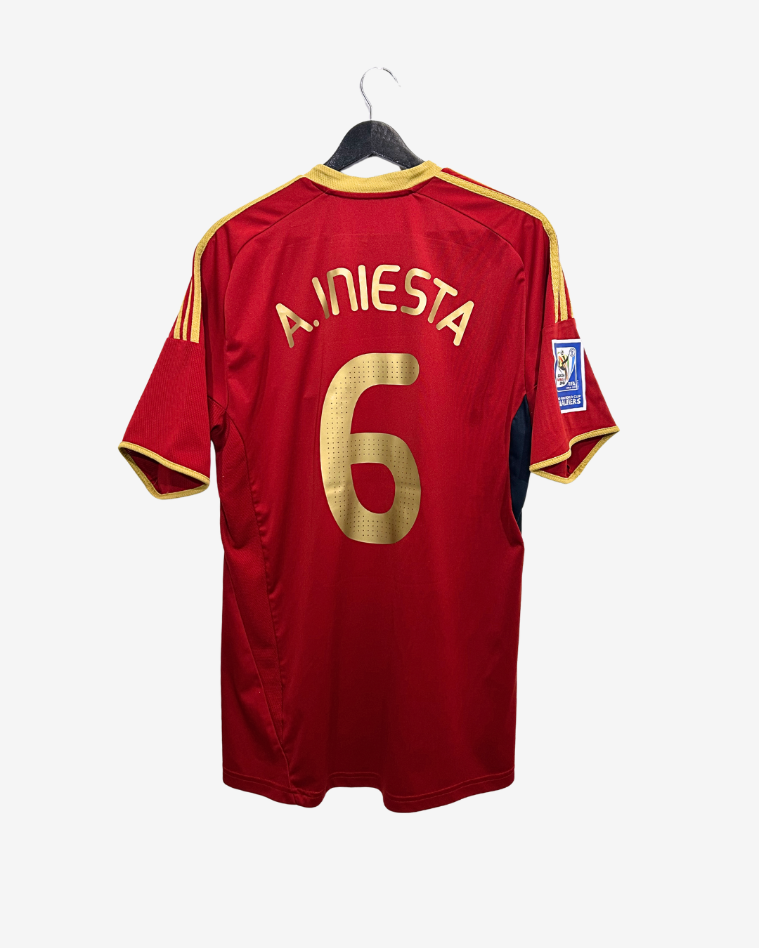 Red sports jersey with gold lettering and number on a hanger against a white background