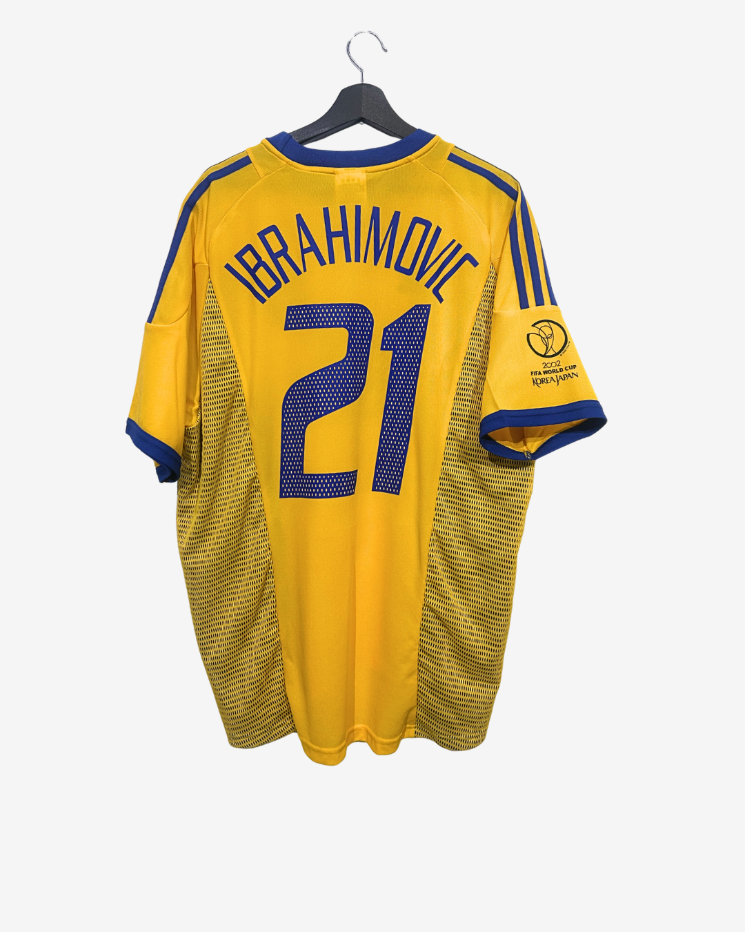 Yellow sports jersey with 'Ibrahimovic' and number '21' on a hanger against a white background