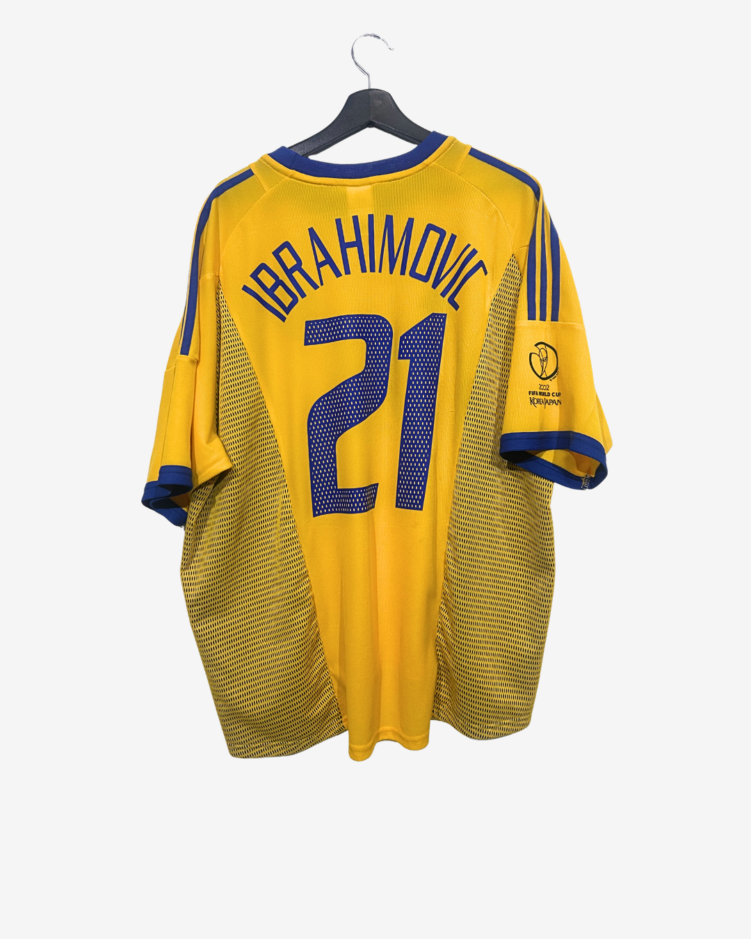 Yellow sports jersey with 'Ibrahimovic 21' on a hanger against a white background