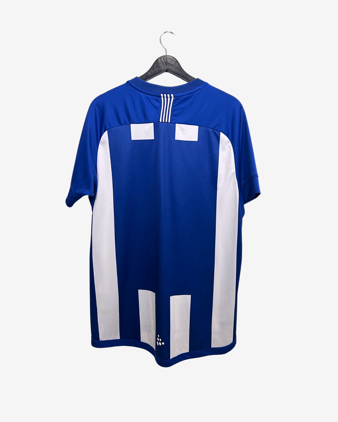 Blue and white sports jersey on a hanger against a white background