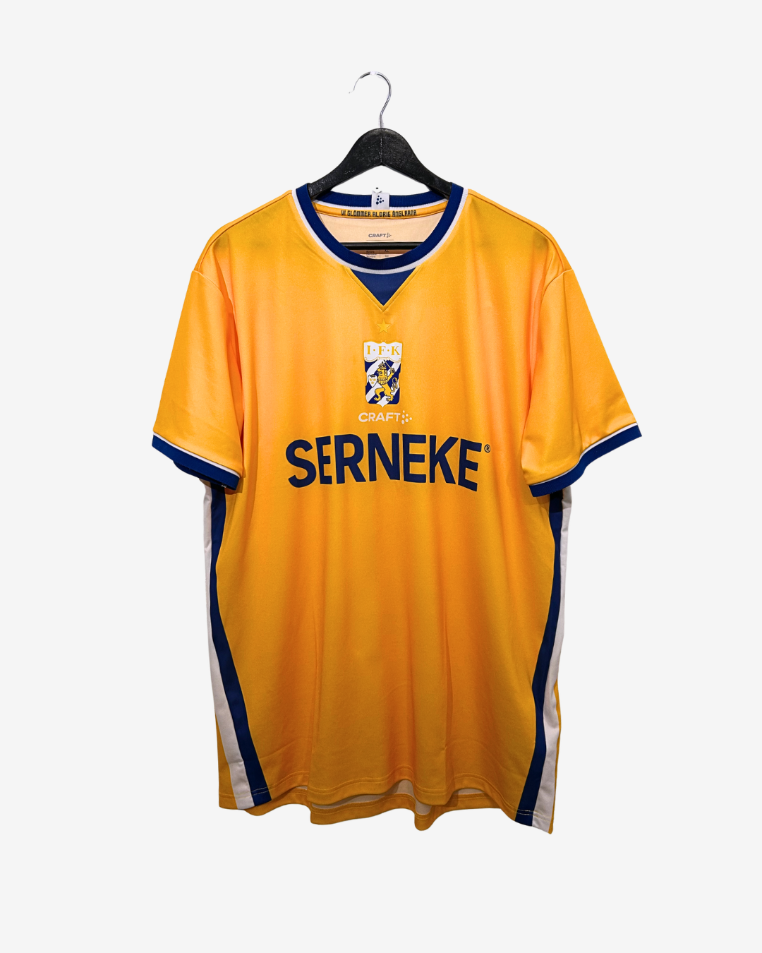 Yellow sports jersey with 'Serneke' branding on a hanger against a white background
